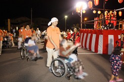 スタッフと盆踊りに参加する様子